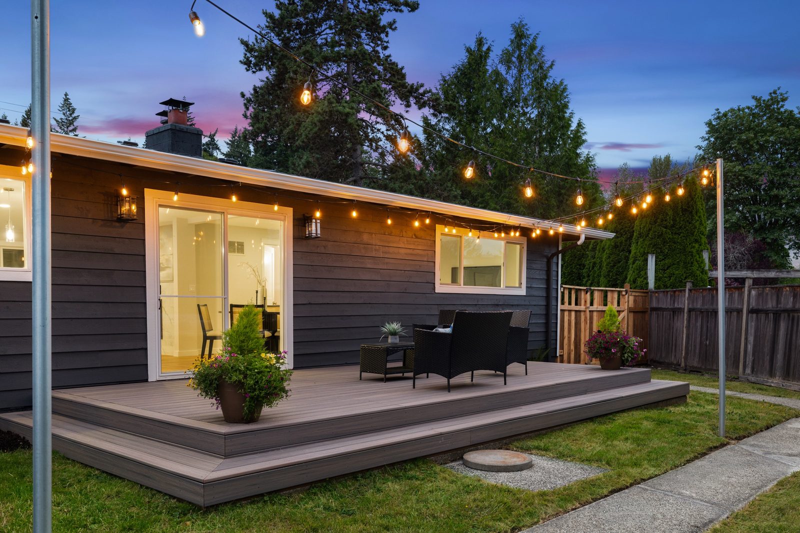 Back deck with string lights at dusk on a refreshed Eastside rambler