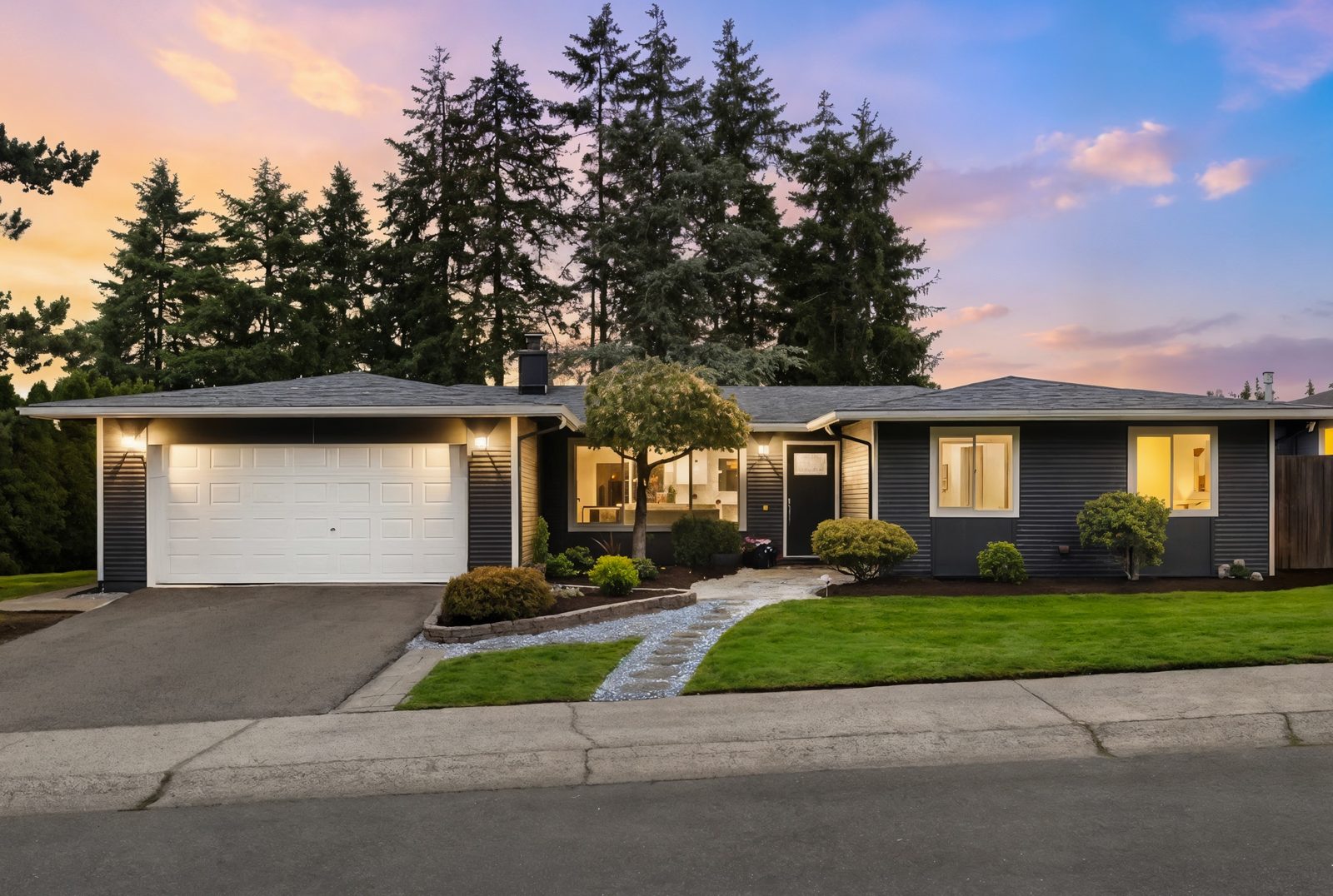 Single story Eastside home with fresh exterior paint, new landscaping and a lit entry at dusk