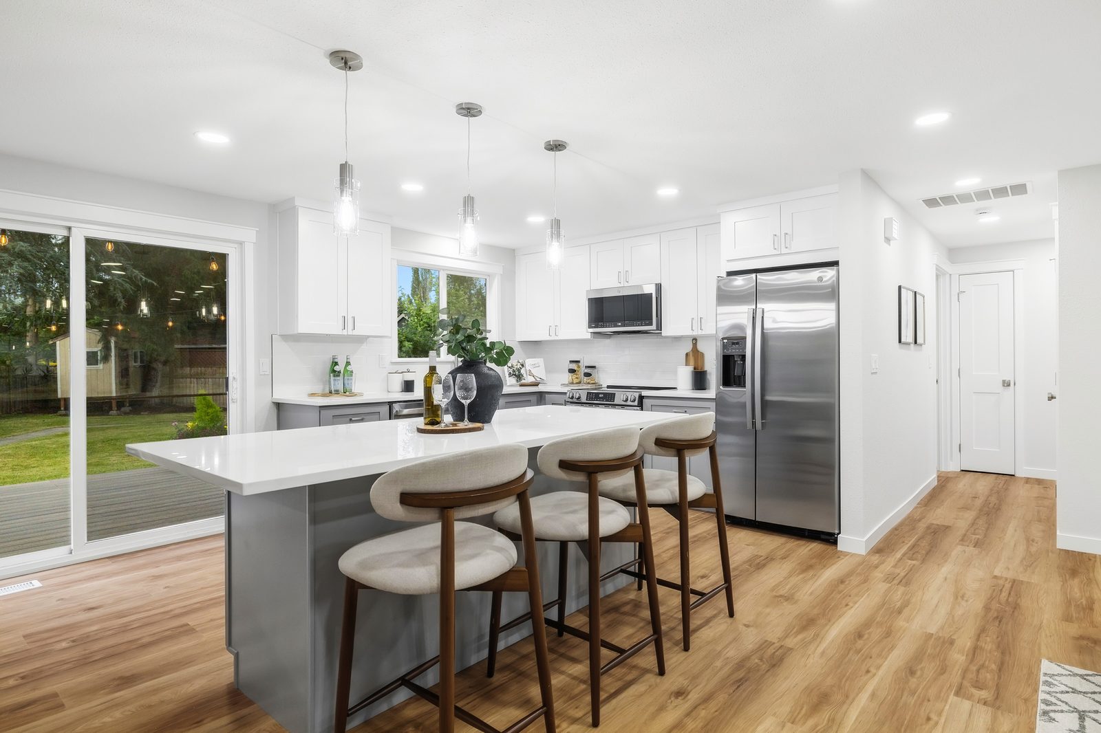 Bright white kitchen with a center island and pendant lights