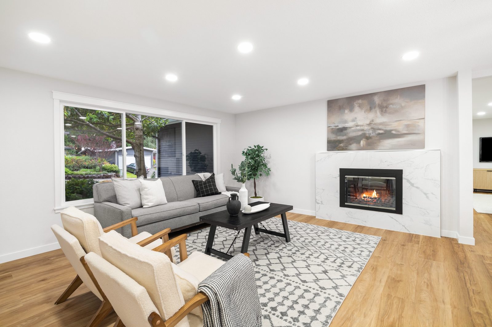 Bright, staged living room with a fireplace and new flooring, ready for listing photos